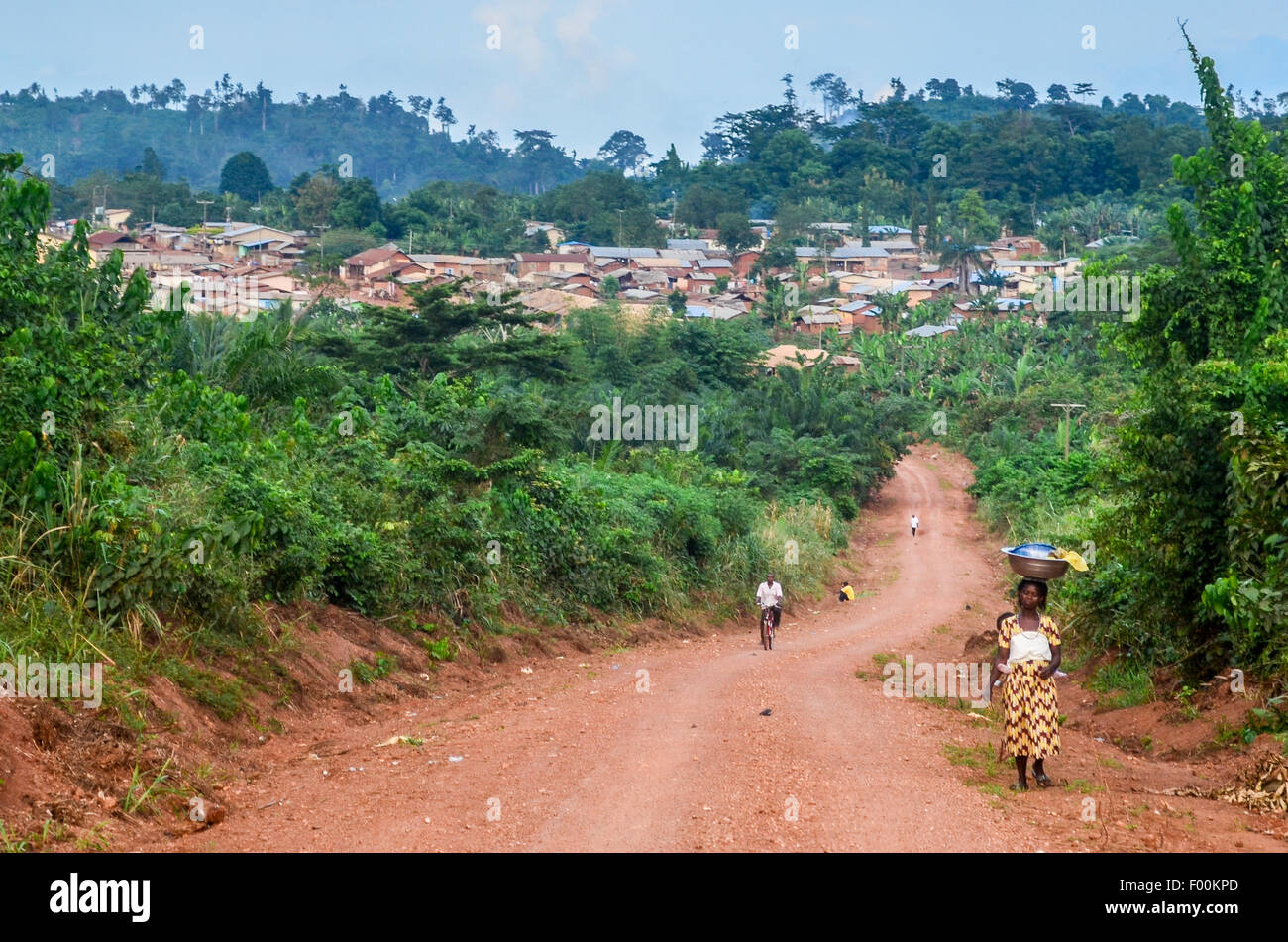 Las mujeres portadoras de cosas en la cabeza en un camino de tierra cerca de una aldea Ashanti en Ghana Foto de stock