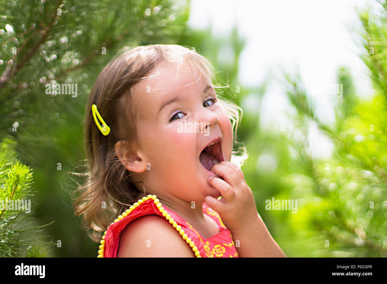 Chica con la mano en la cara riendo Foto de stock
