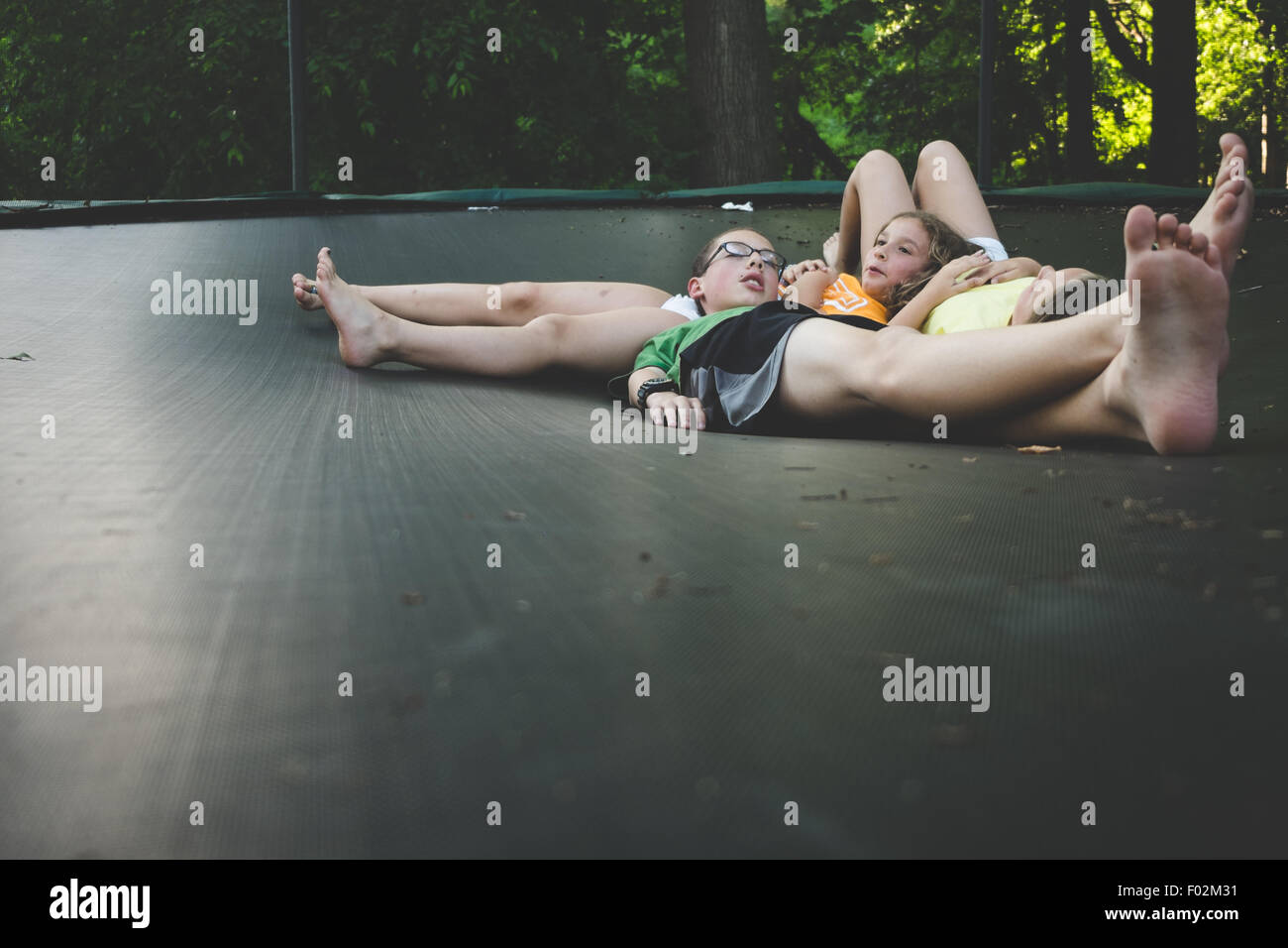Tres niñas relajándose en un trampolín Foto de stock