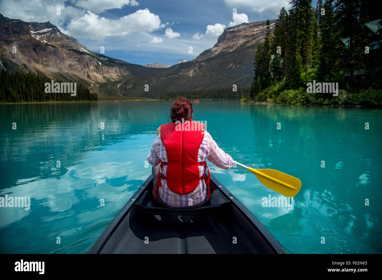 Mujer canotaje en el lago Esmeralda, el Parque Nacional Yoho, British Columbia, Canadá Foto de stock