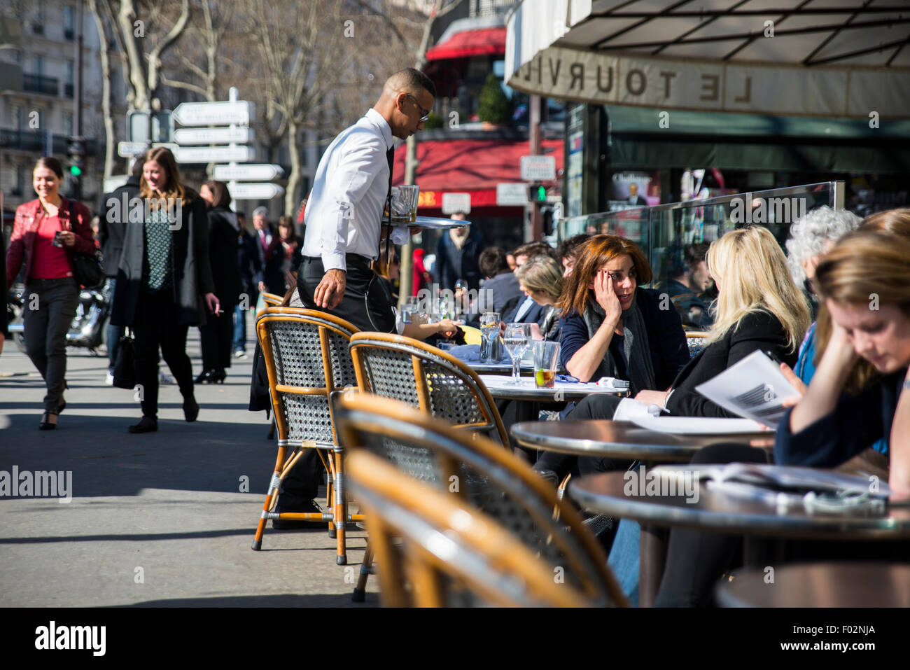 Camarero sirviendo bebidas a los clientes en Le Tourville cafe en Paris, Francia Foto de stock