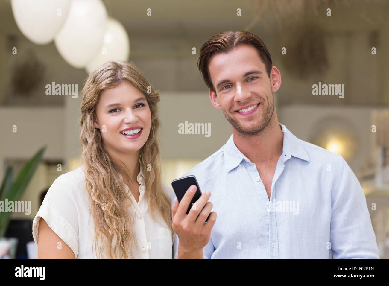 Retrato de una feliz pareja mirando el smartphone Foto de stock