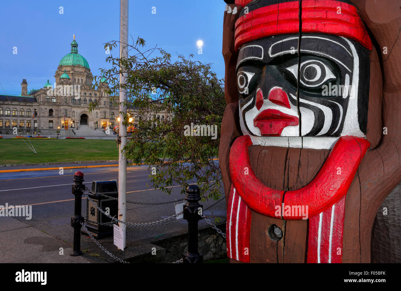Las primeras naciones aborígenes tótem y edificios legislativos al amanecer-Victoria, British Columbia, Canadá. Foto de stock