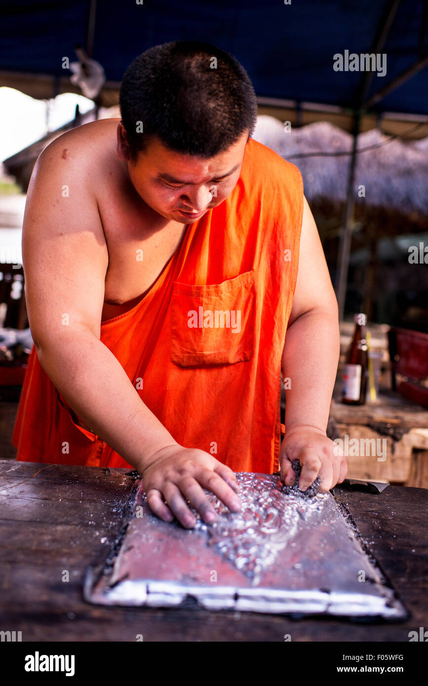 Monje budista trabajando en arte metal prensado en Wat Sisuphan en Chiang Mai, Tailandia, en Asia. Foto de stock