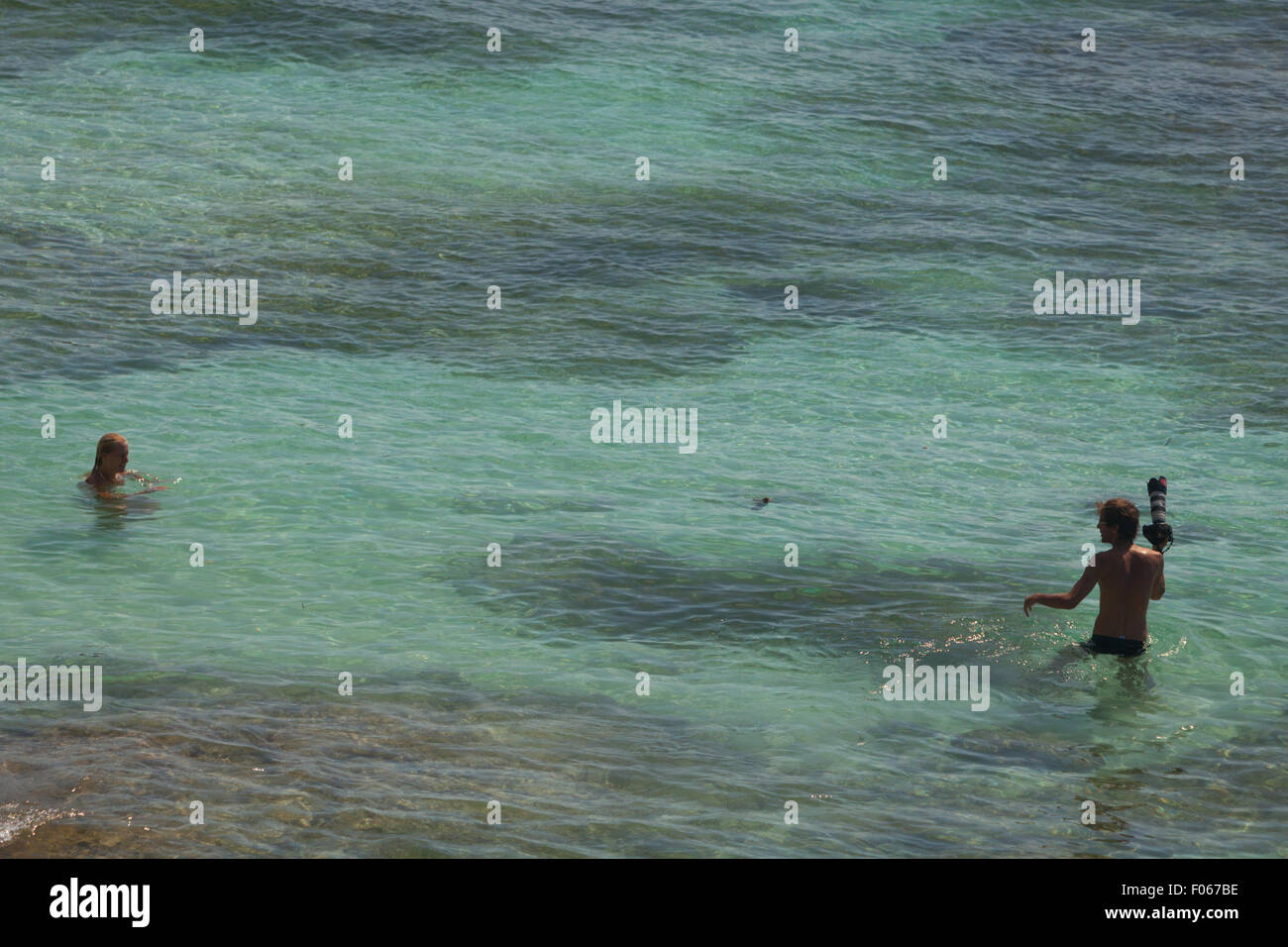 Turistas haciendo sesión de fotos en aguas poco profundas en la playa de Padang-padang, Labuan Sait, Kuta del Sur, Badung, Bali, Indonesia. Foto de stock