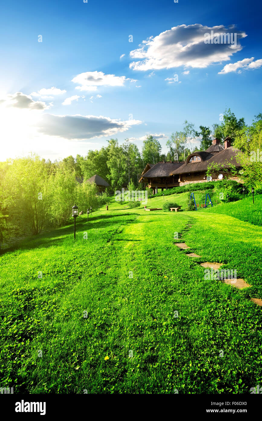 Casas de madera en verde pradera en primavera Foto de stock