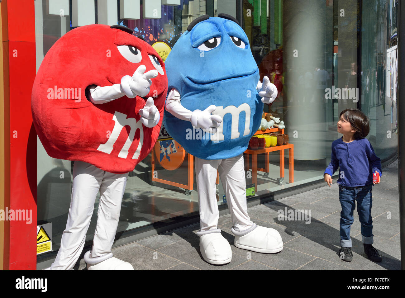 Niño con M&M caracteres fuera de M&M's World, Swiss Cottage, Leicester Square, el West End, la ciudad de Westminster, London, United Ki Foto de stock