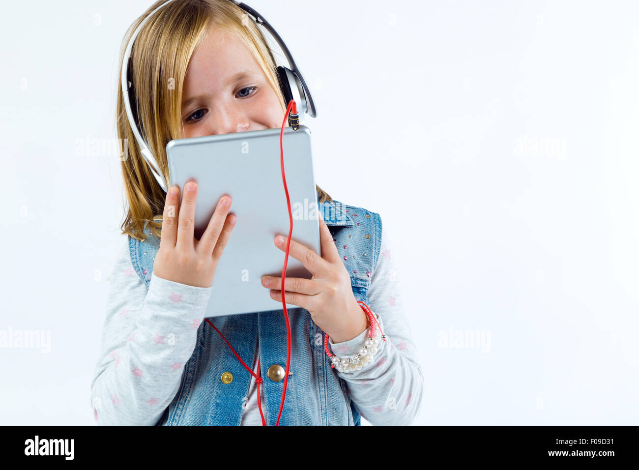 Retrato de niño hermoso escuchar música con tableta digital. Foto de stock