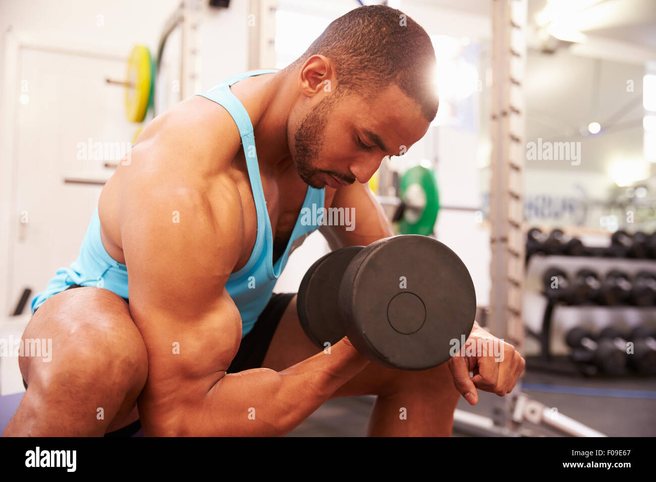 Hombre el ejercicio con pesas en el gimnasio, disparo horizontal Foto de stock