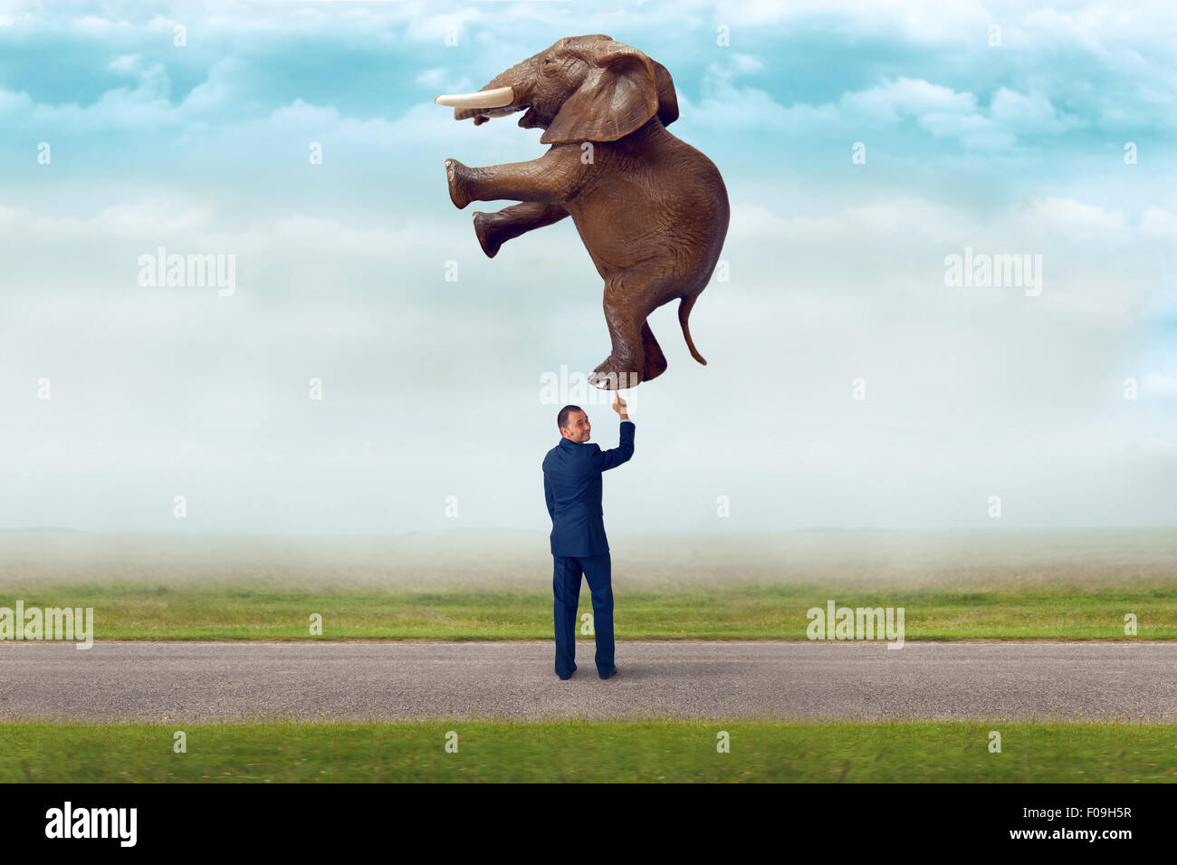 La fuerza del negocio concepto empresario sosteniendo un elefante con un dedo Foto de stock