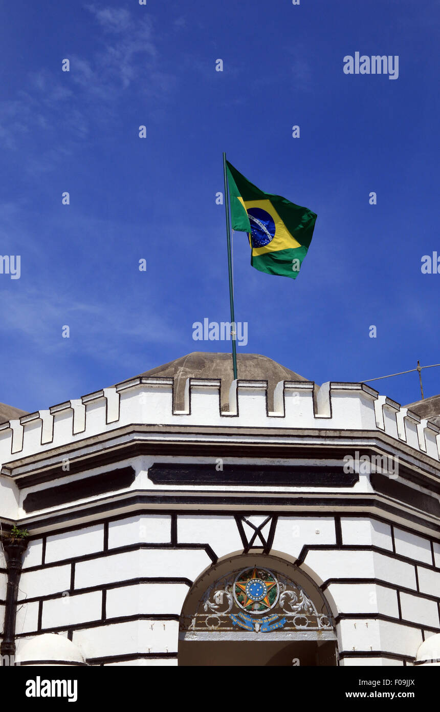 La bandera brasileña sobrevuela el Fuerte de Copacabana. Foto de stock