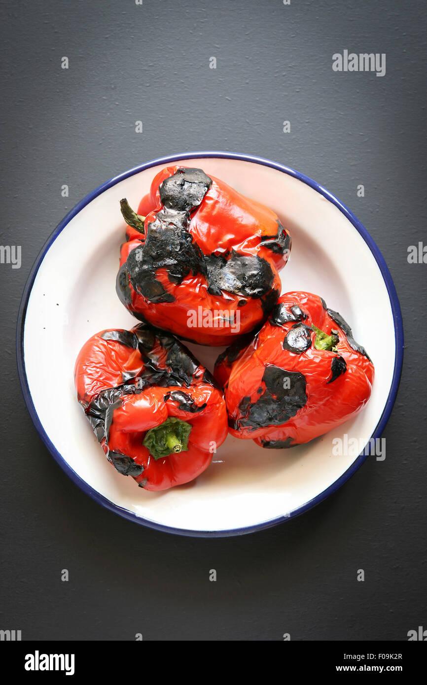 3 pimiento rojo asado sobre una placa de esmalte.vista superior Foto de stock