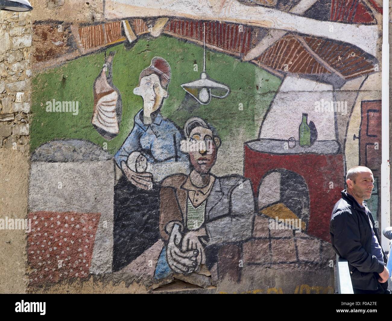 Hombre de pie junto a los murales de Orgosolo, Nuoro, Cerdeña, Italia Foto de stock