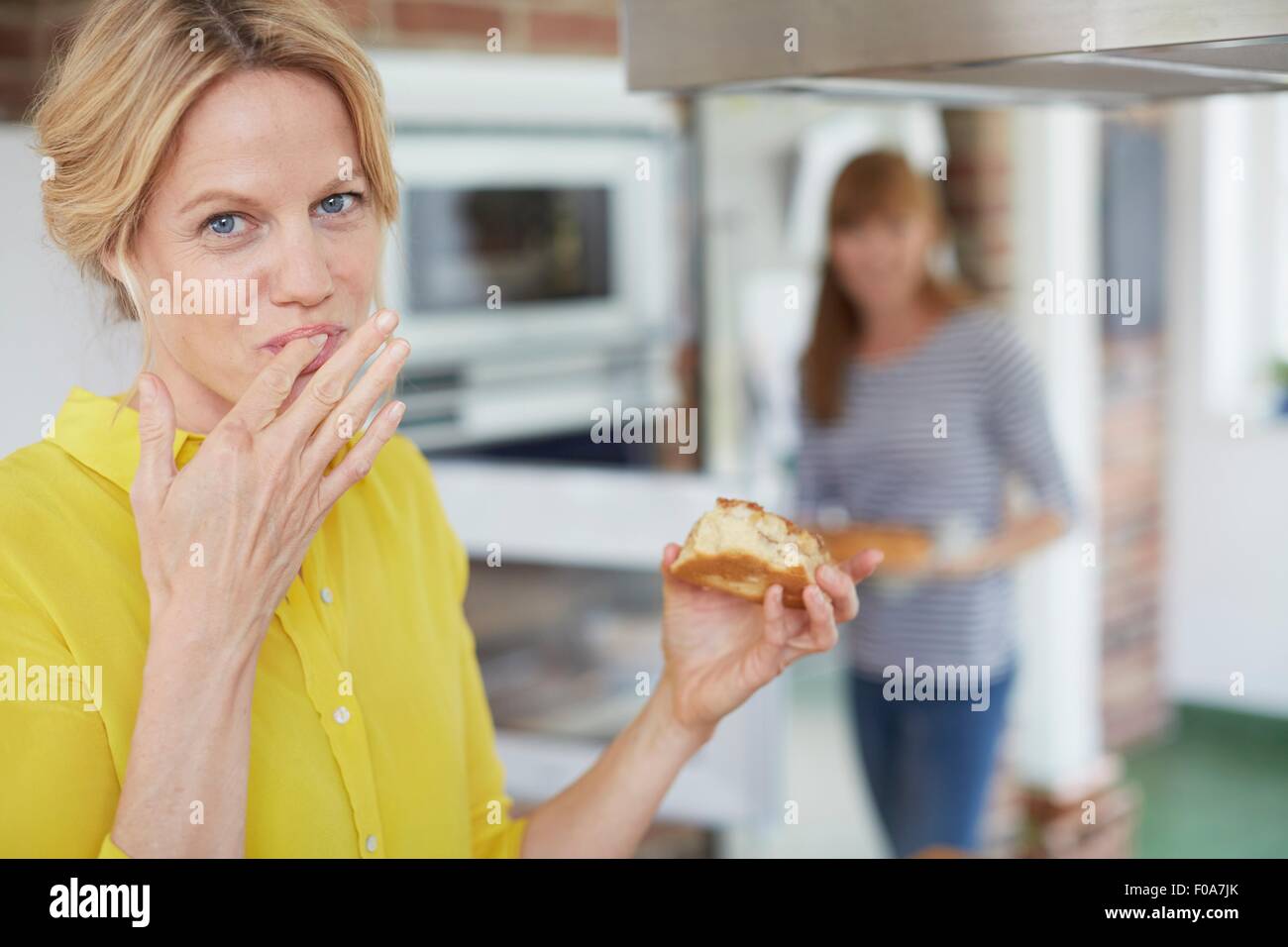 Mujeres comer pastel en la cocina Foto de stock