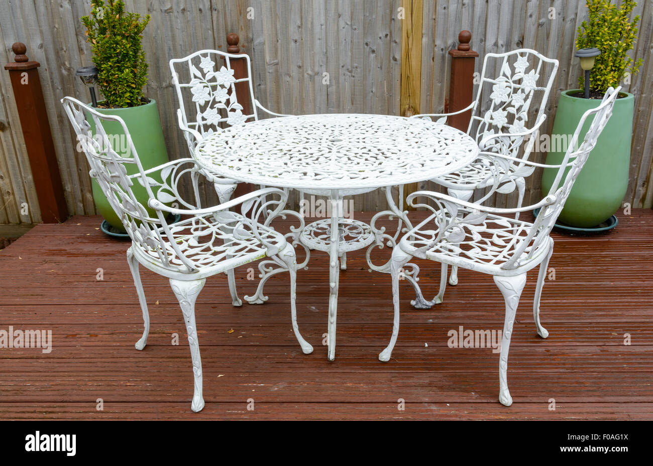 Hierro fundido blanco mesa y sillas de jardín en un jardín trasero. Foto de stock