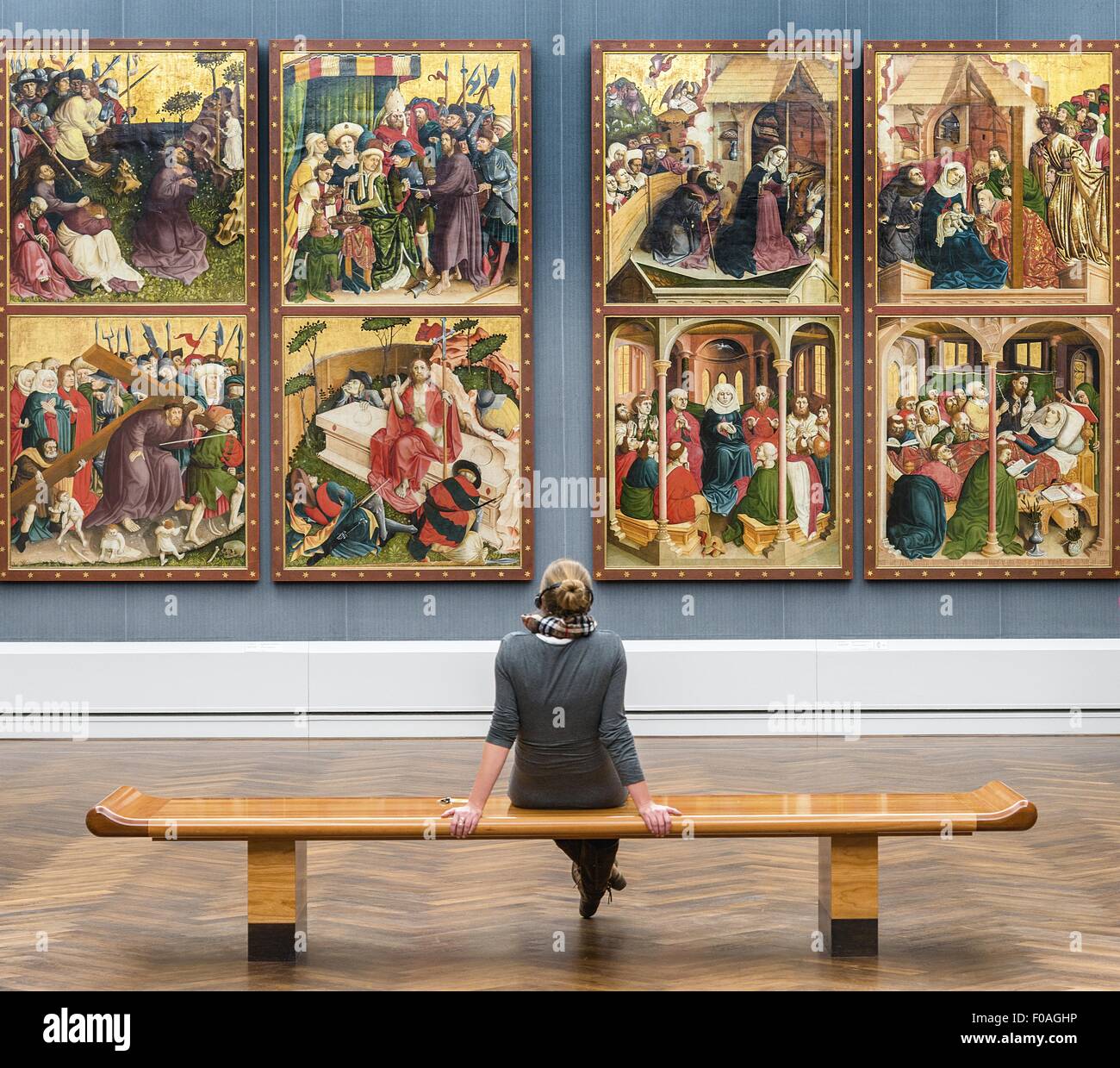 Mujer sentada en un banco y mirando las fotos en los Museos Estatales de Berlín, Berlín, Alemania Foto de stock