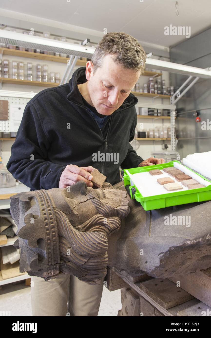 El restaurador Uwe difícil trabajar en escultura en Munsterbauhutte, Freiburg, Alemania Foto de stock
