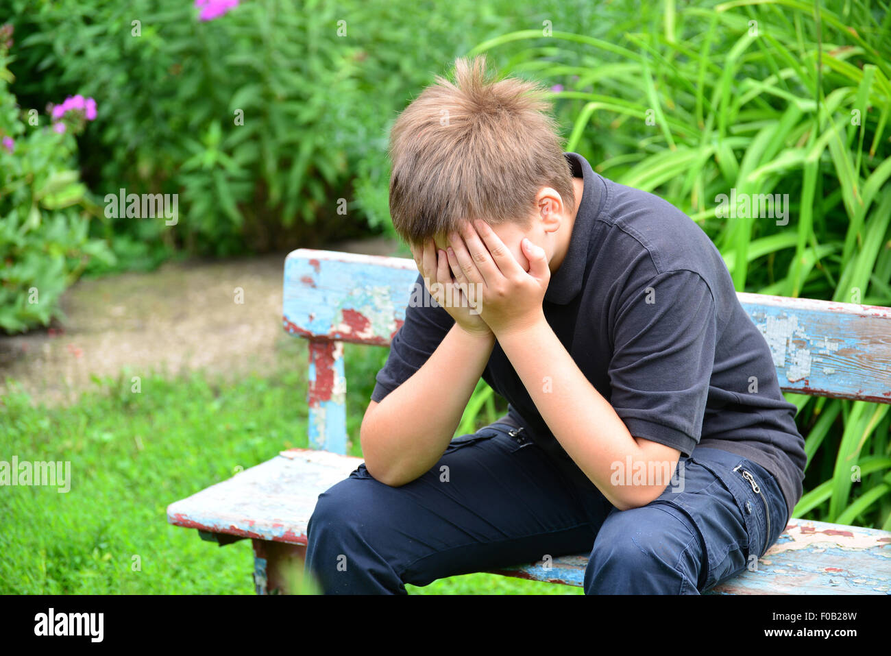Un adolescente deprimido sentado en el banco Foto de stock