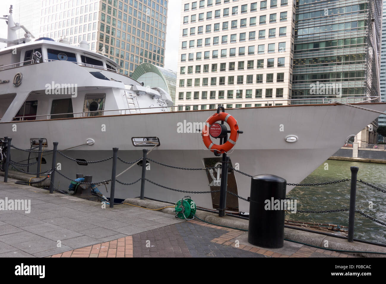 Un crucero blanco llamado "placer absoluto" está acoplado al lado de una boya en South Quay en Londres. Foto de stock