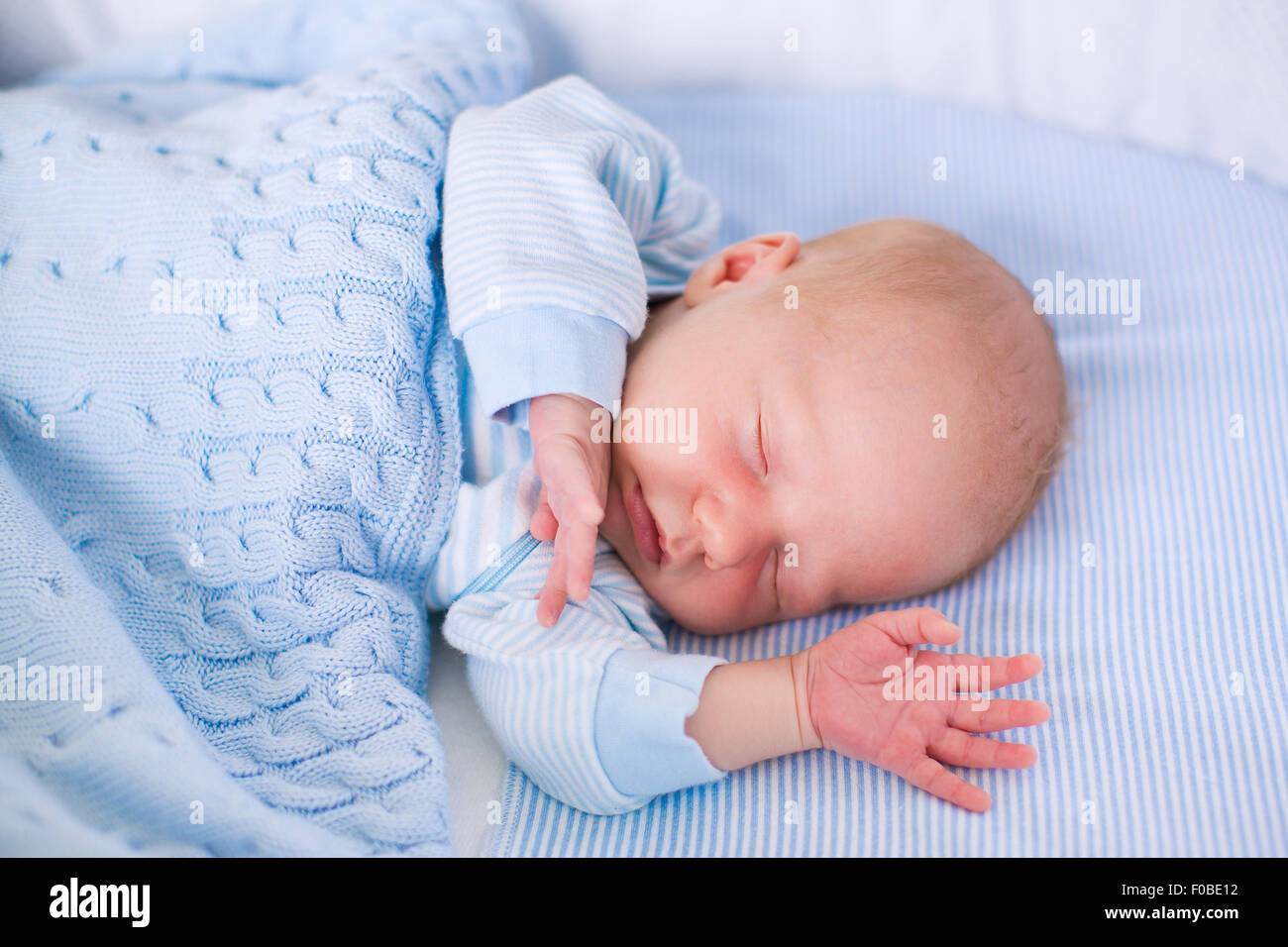 Bebé recién nacido niño en cama. Niño recién nacido duerme bajo