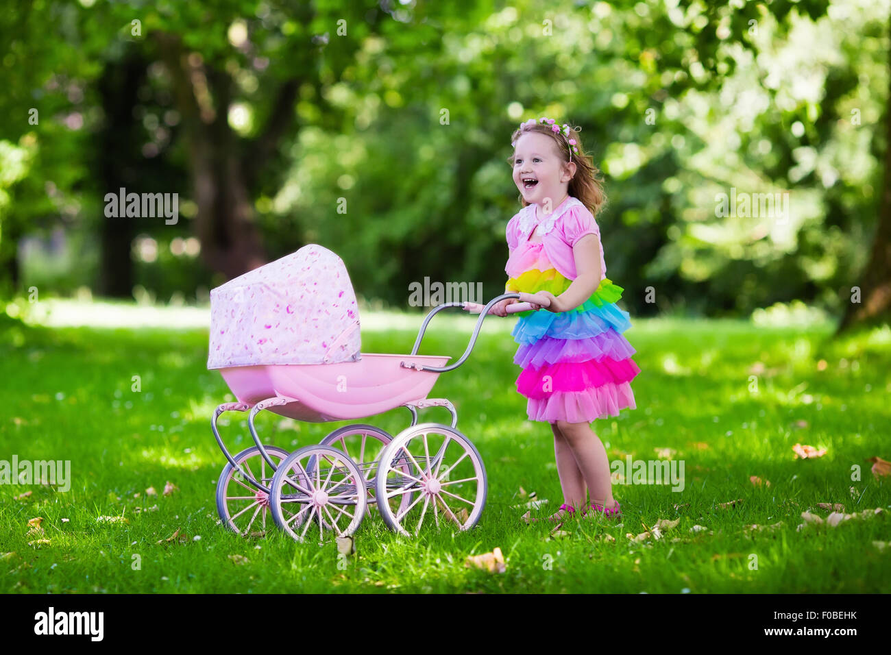 Niña empujando cochecito de juguete con oso. Infante vestido rosado cabrito  en buggy jugar con muñecas. Fiesta de cumpleaños para niños Fotografía de  stock - Alamy