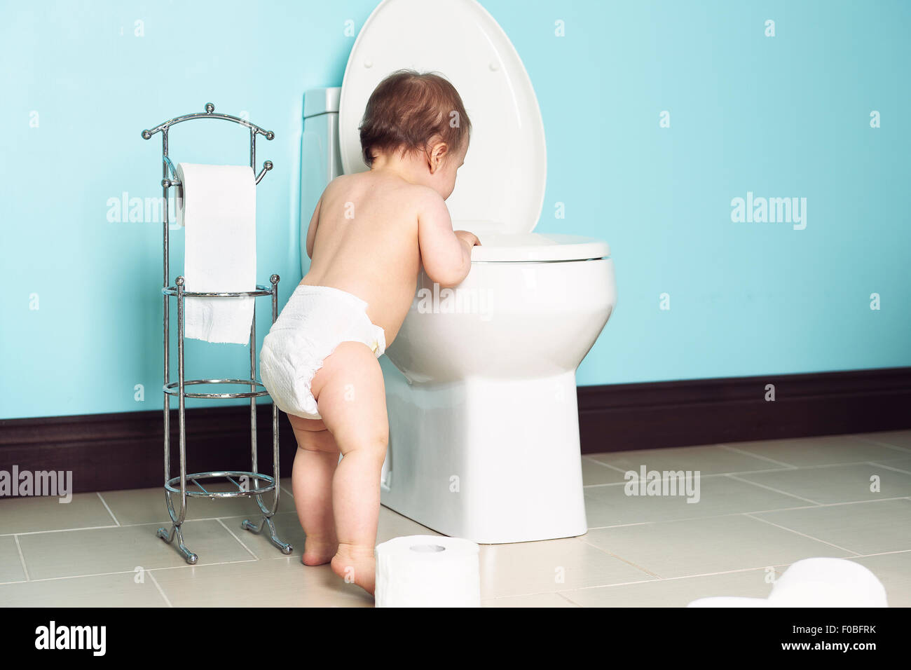 Niño en el baño mirar el wc Foto de stock