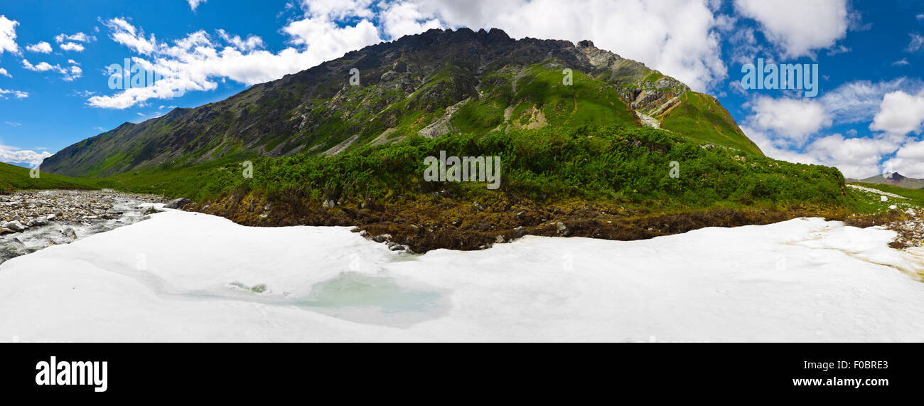 Vista panorámica de verano con el río y la nieve en las montañas Sayan. Foto de stock
