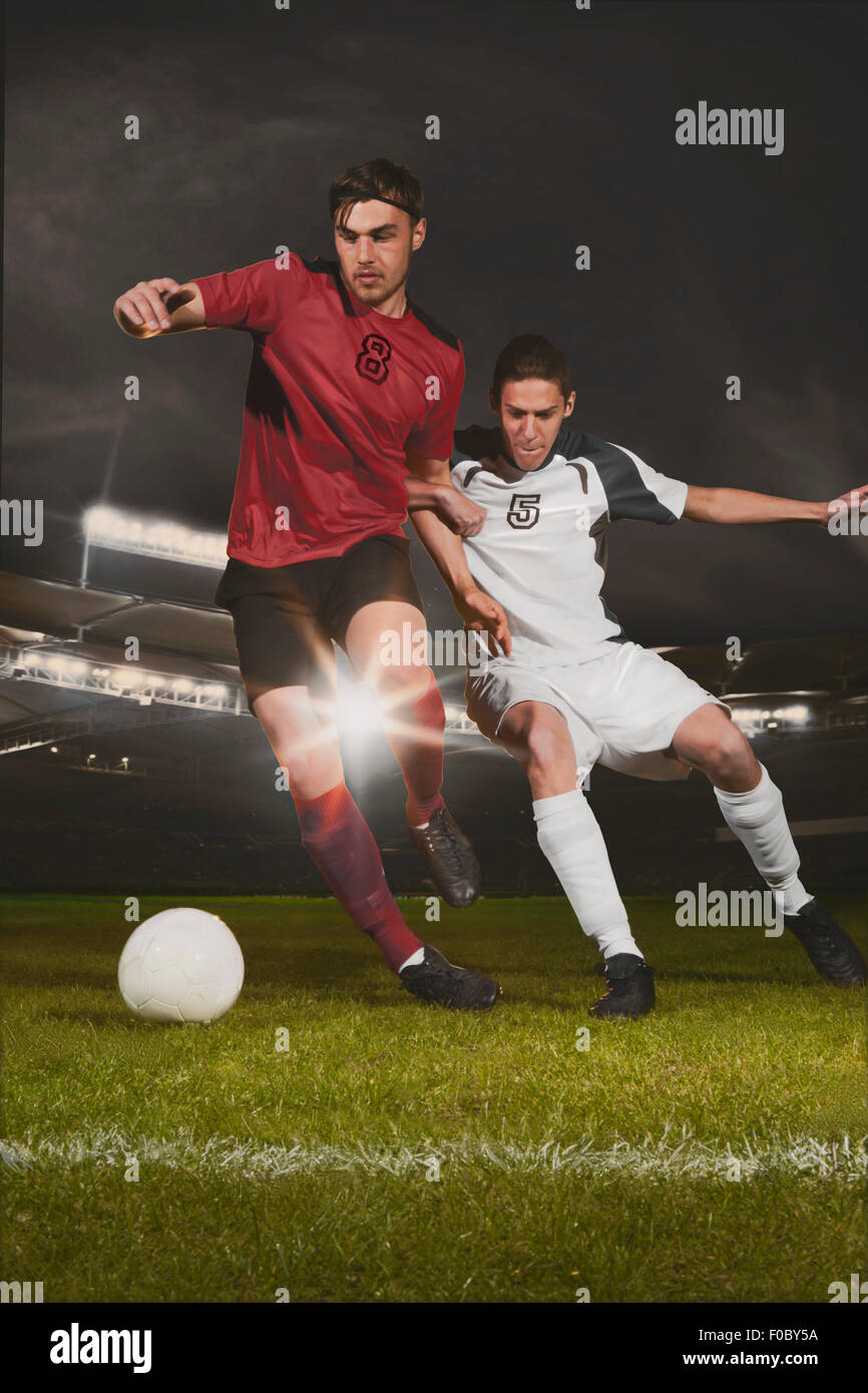 Longitud total de jóvenes jugadores de fútbol masculino abordar durante el match ball Foto de stock
