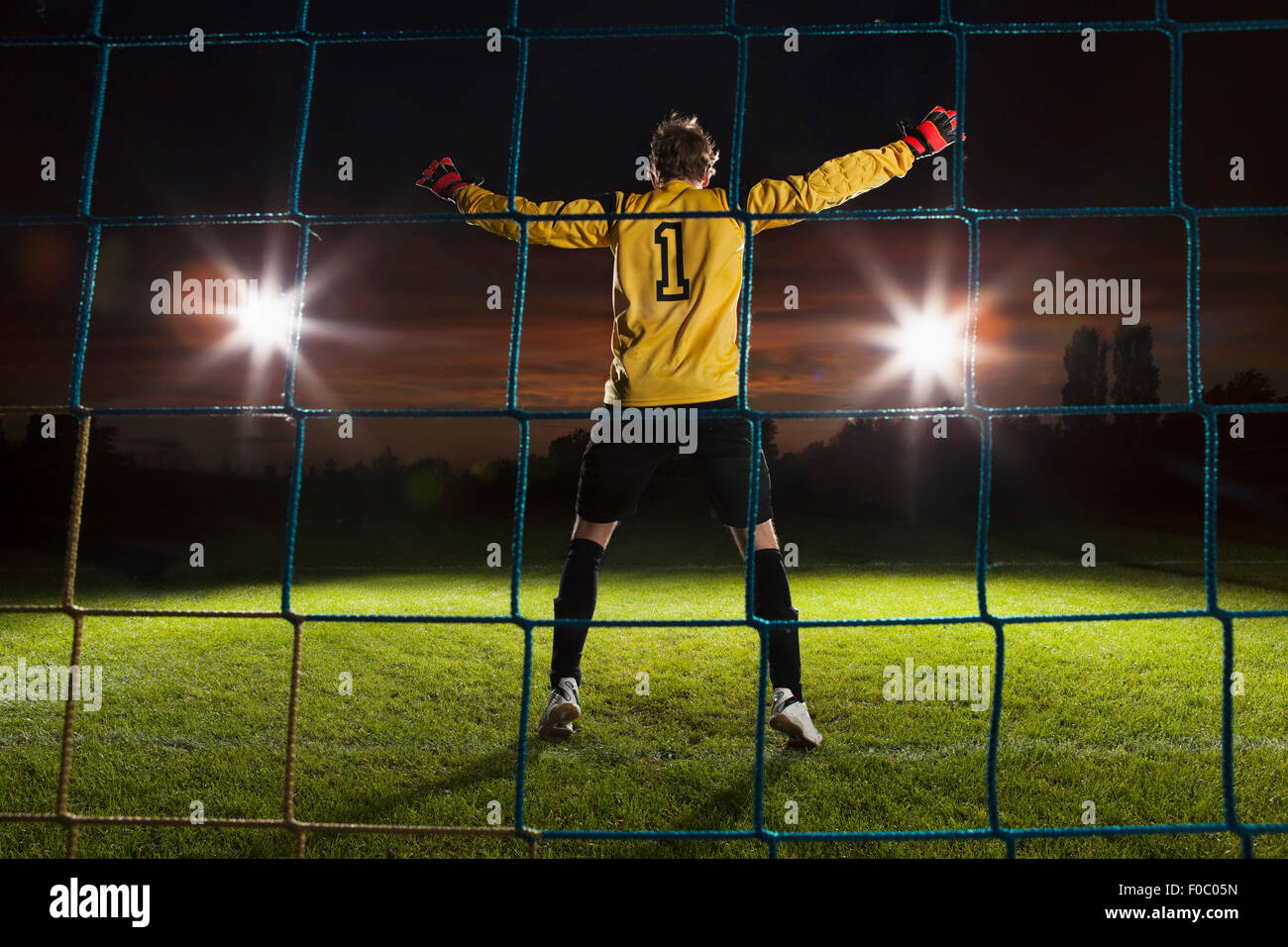 Vista trasera de la longitud completa de portero defensa soccer net en campo Foto de stock