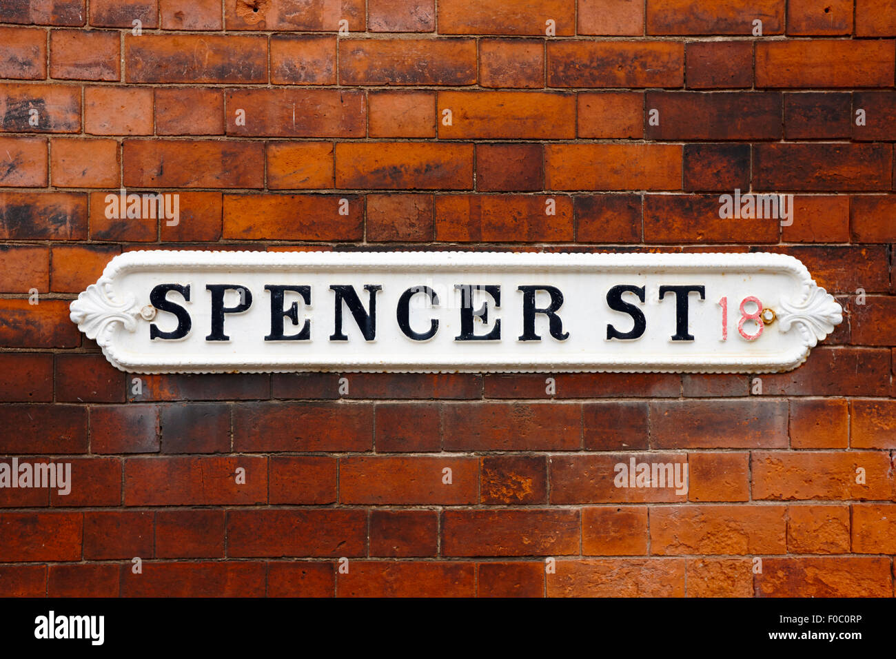 Victorian Metal calle signo para Spencer Street en edificio de ladrillo rojo en el barrio de las joyerías Birmingham UK Foto de stock