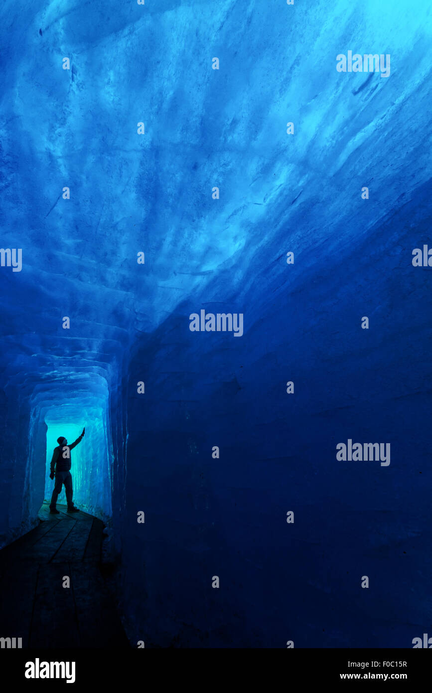 Hombre silueta en la cueva de hielo. El glaciar del Ródano, Suiza, Europa. Foto de stock