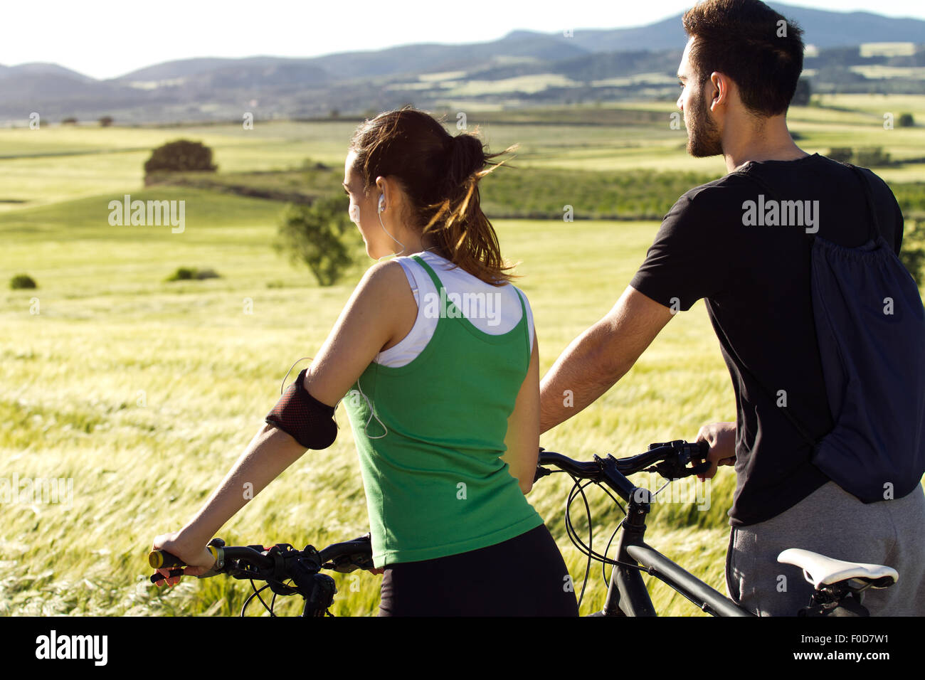 Primavera retrato de joven pareja feliz en un paseo en bicicleta en el campo Foto de stock