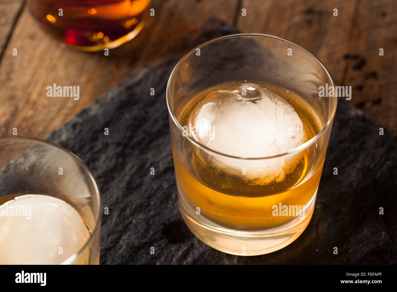 Whisky Bourbon con una esfera cubo de hielo listo para beber Foto de stock