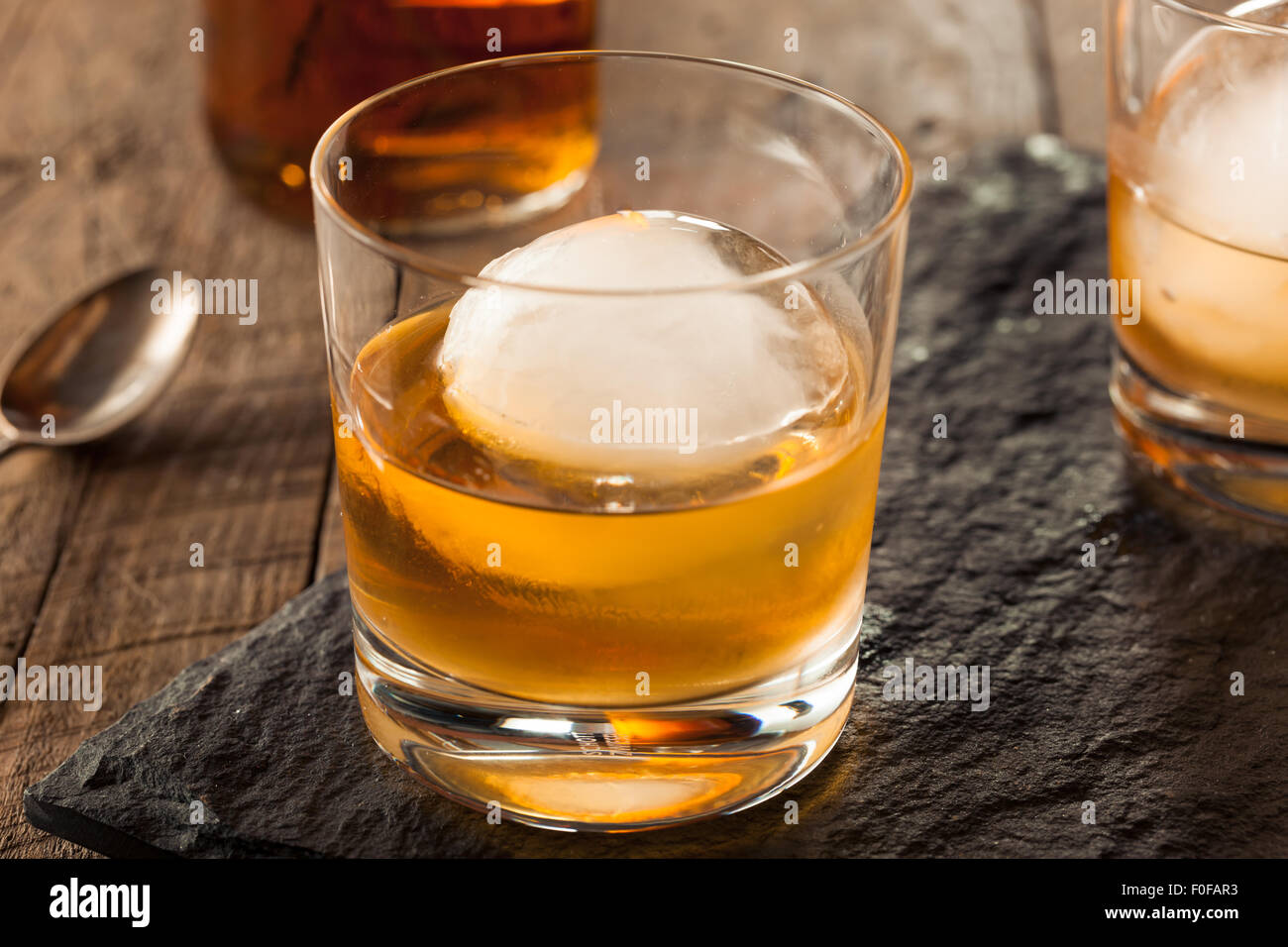 Whisky Bourbon con una esfera cubo de hielo listo para beber Foto de stock
