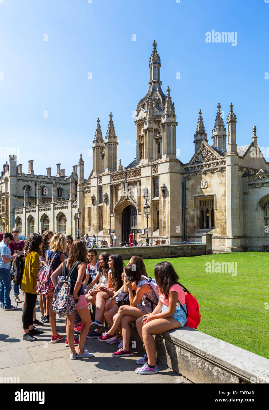 Los jóvenes estudiantes extranjeros sentado fuera de King's College, King's Parade, Cambridge, Cambridgeshire, Inglaterra, Reino Unido. Foto de stock