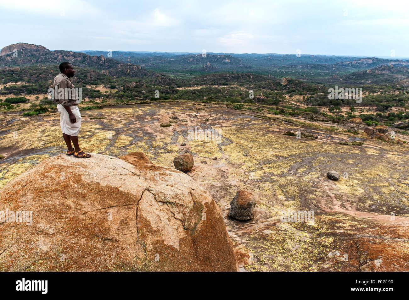 Hombre de pie sobre la roca vista del mundo oriental cordillera montañosa de África Zimbabwe Foto de stock