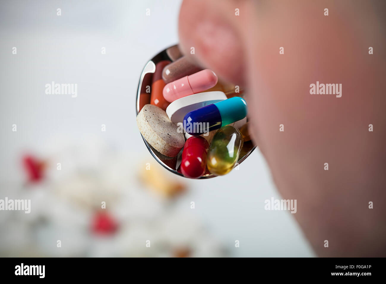 Boca con una cuchara llena de pastillas Foto de stock