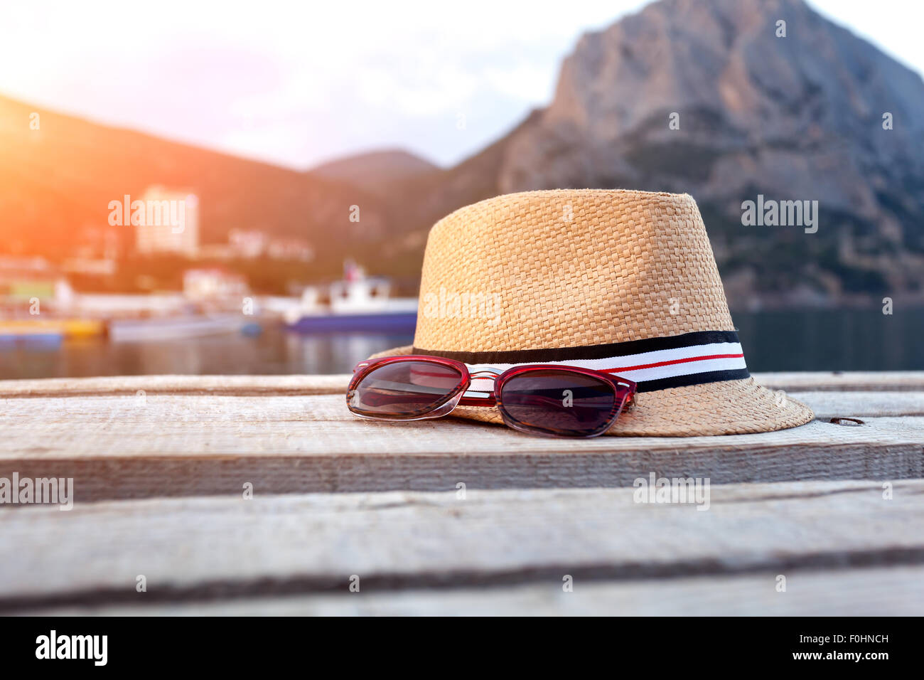 Gafas de sol, sandalias y sombrero en la textura de la madera en verano. Foto de stock