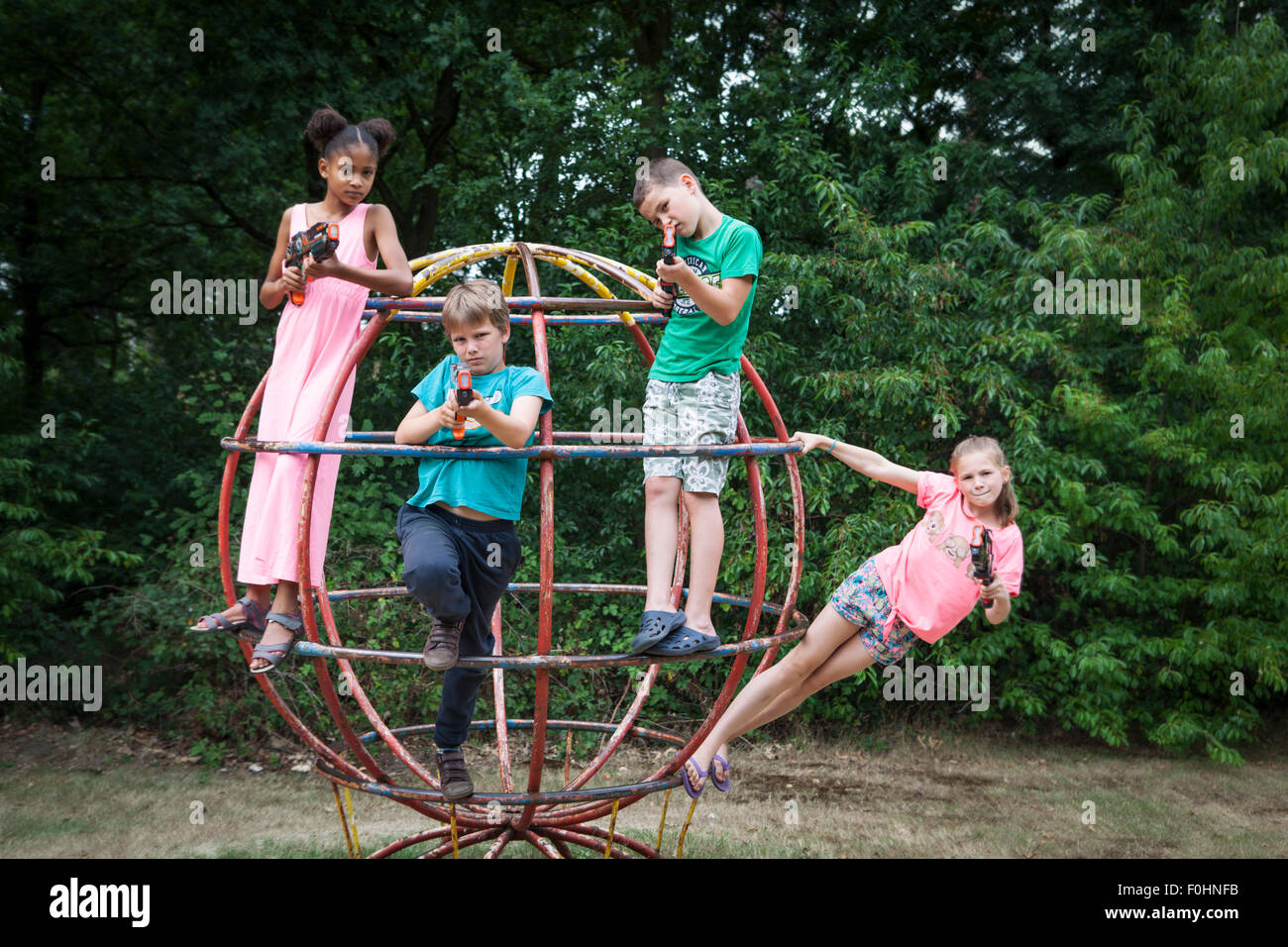 Niños y niñas posando y jugando con la luz huelga pistolas láser outdoor Foto de stock