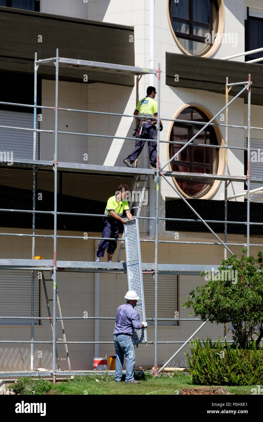 Los trabajadores de la construcción la instalación de andamios en un edificio Foto de stock