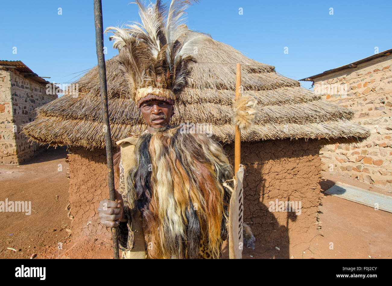Un jefe de aldea local preside una comunidad rural en su vestimenta tradicional. Foto de stock