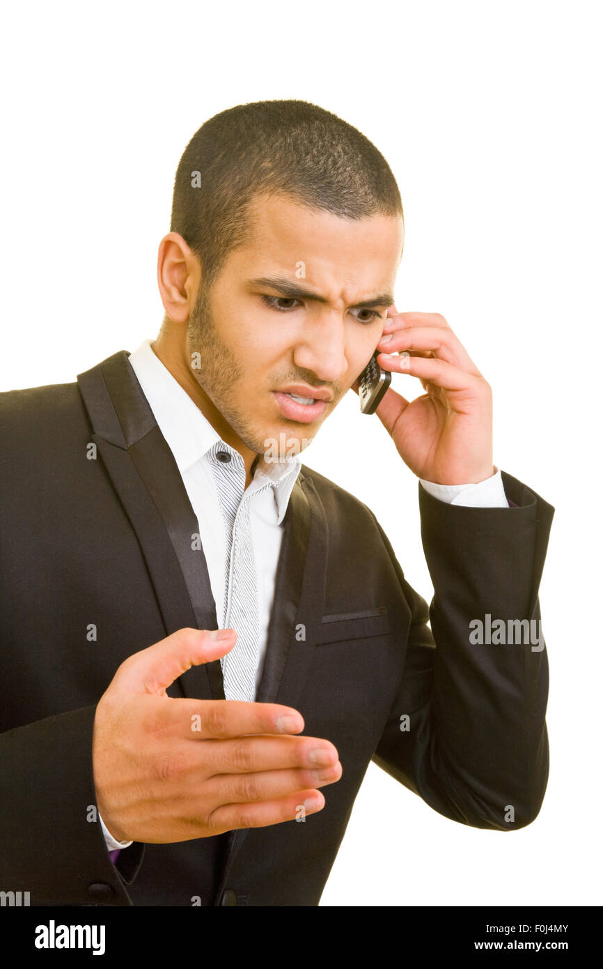 Enojado hombre de negocios hablando por un teléfono celular Foto de stock