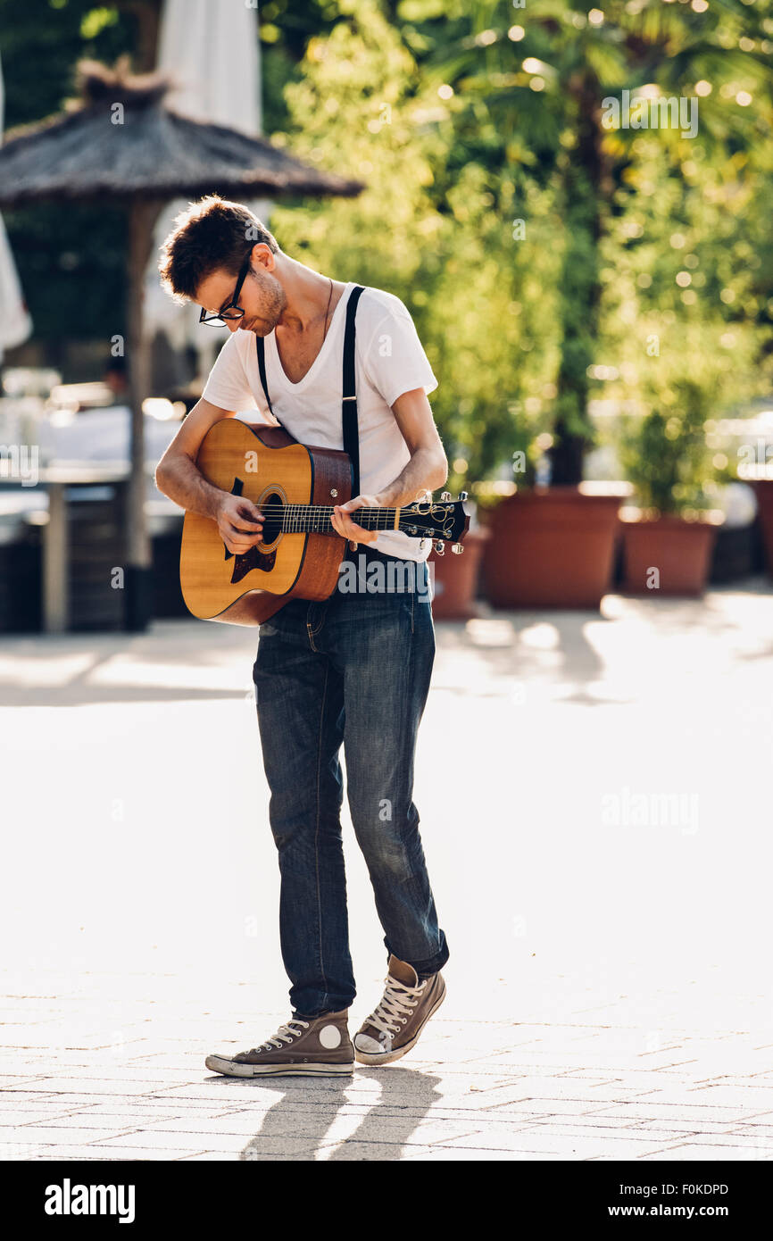 Joven tocando la guitarra en la calle Fotografía de stock - Alamy