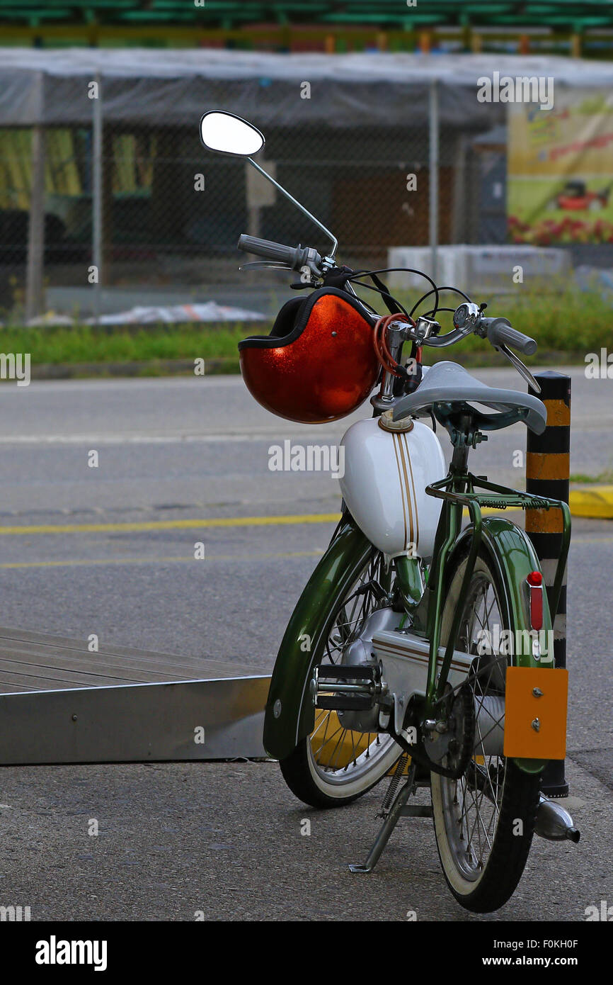 Viejo ciclomotor y casco rojo Foto de stock