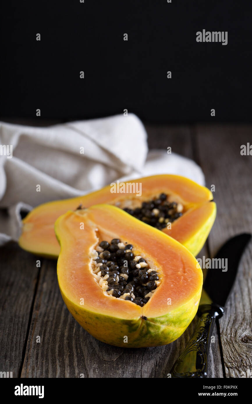 Cortar la fruta exótica de papaya sobre una tabla de madera Foto de stock