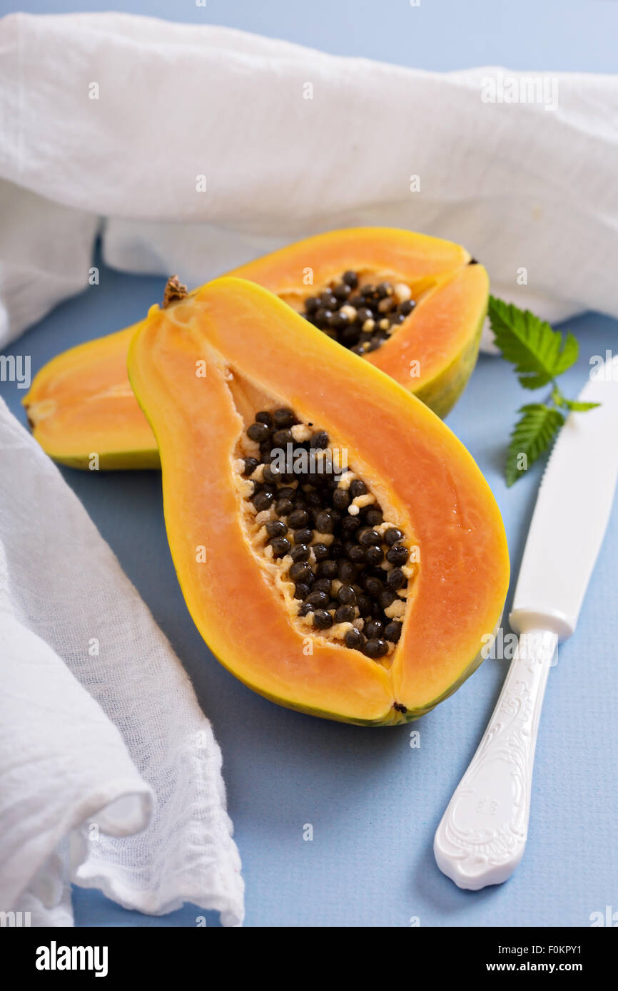 Cortar la papaya fruta exótica en un cuadro azul Foto de stock