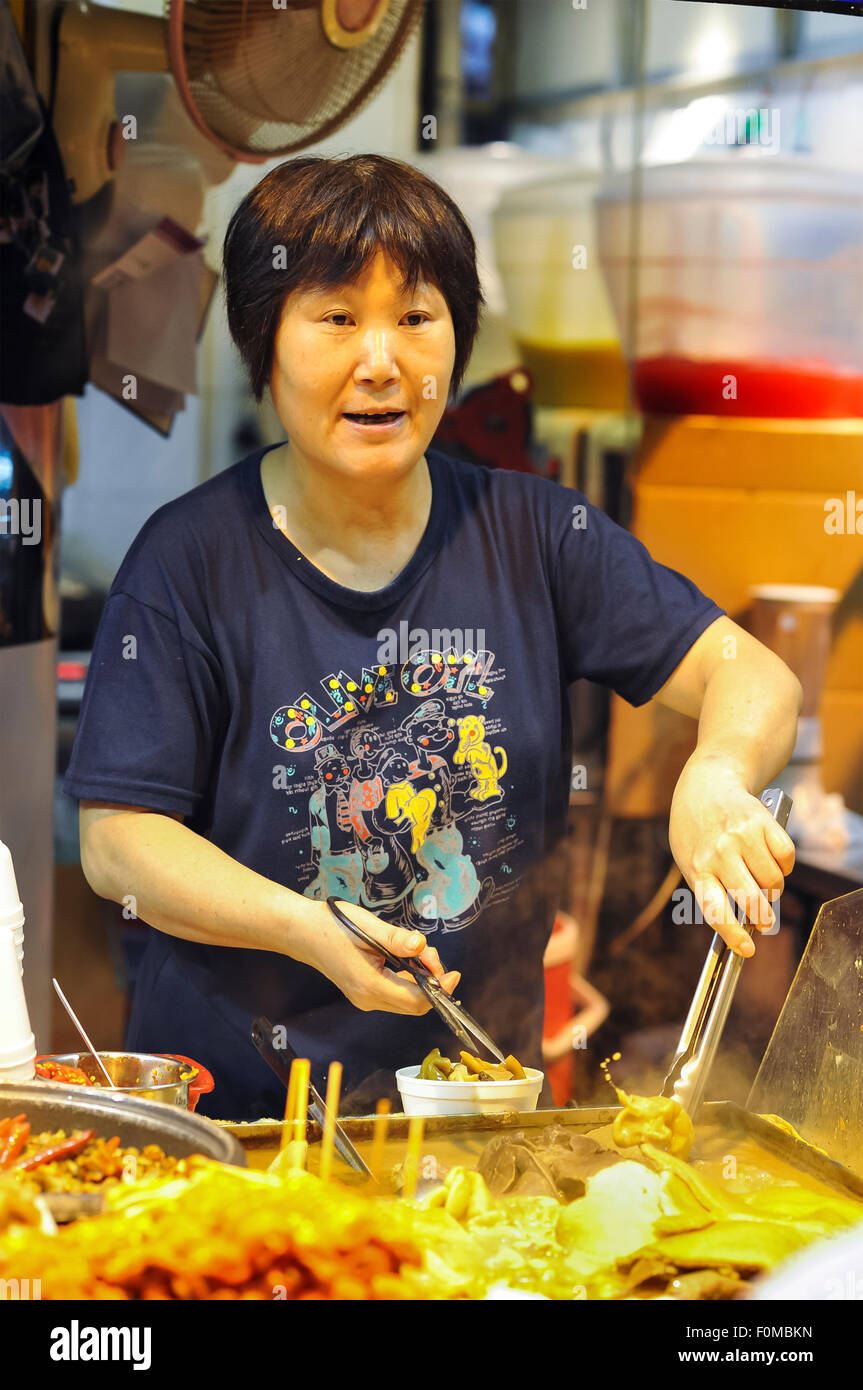 Mujer sirviendo a Ying Heong Yuen Street, puesto de comida, Causeway Bay, Hong Kong Foto de stock