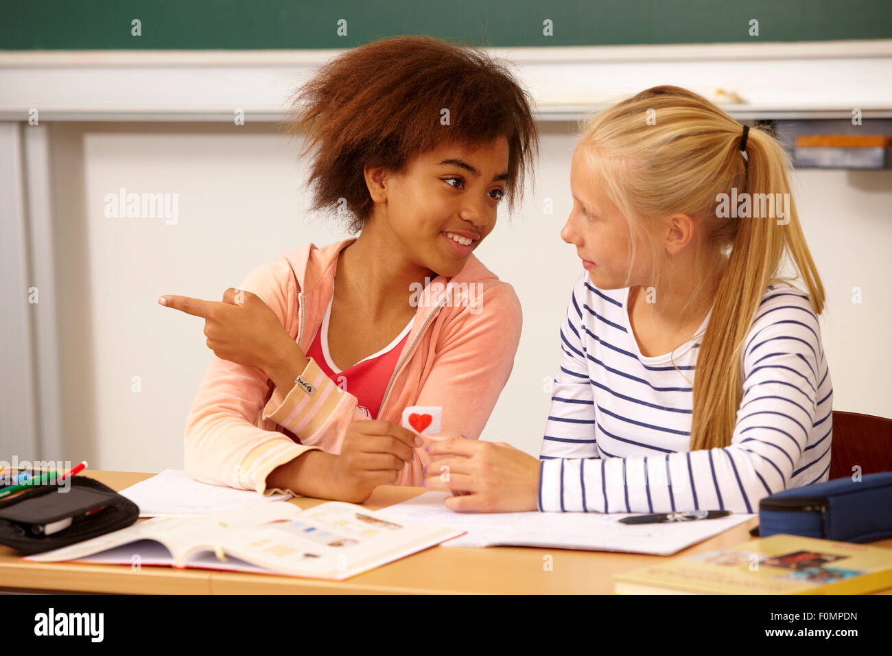 Chica manos sobre una carta de amor a su compañero de clase Foto de stock