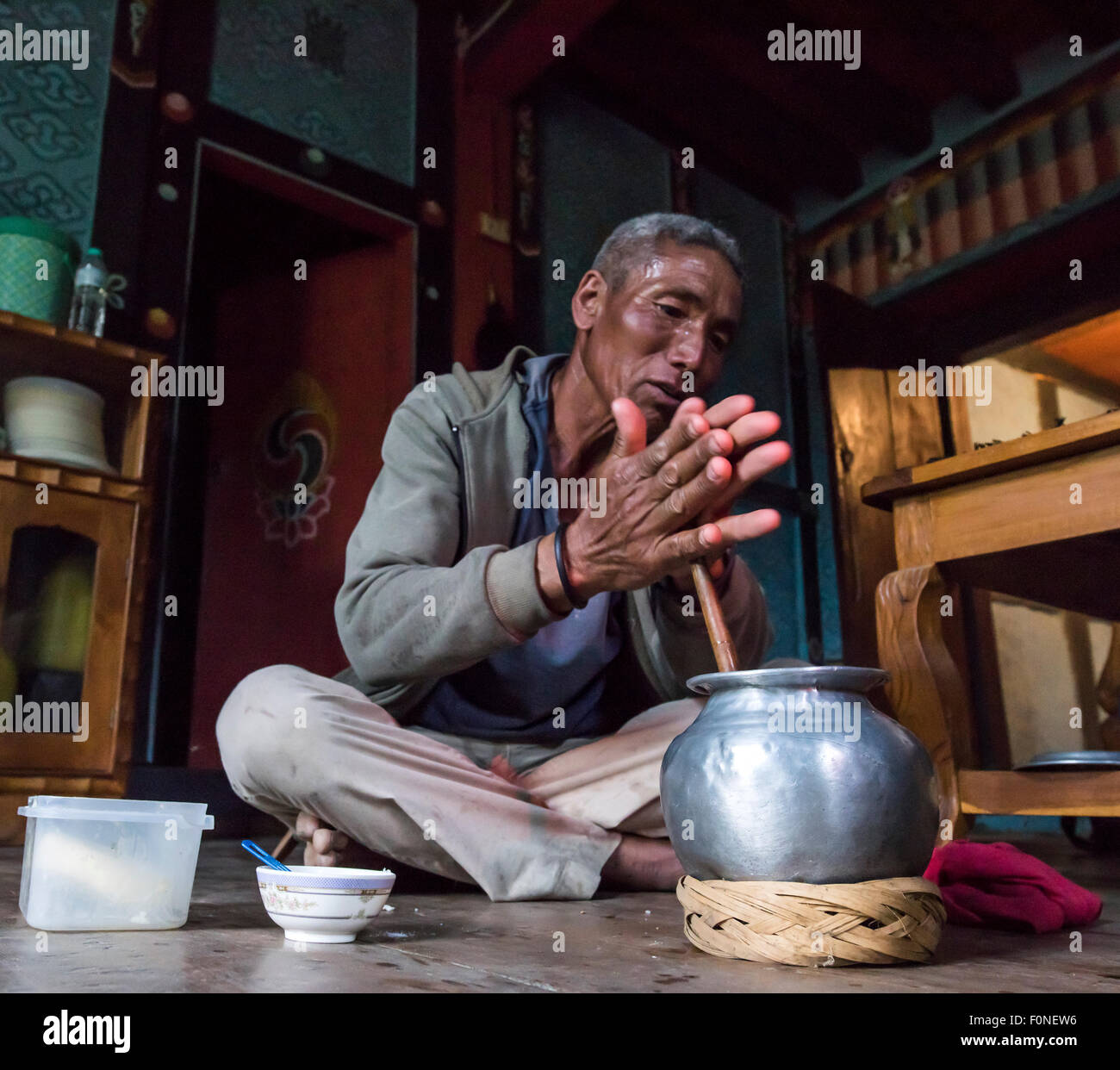 Los bhutaneses hombre preparar té de mantequilla de yak tradicional en una granja típica casa Punakha Buthan Foto de stock