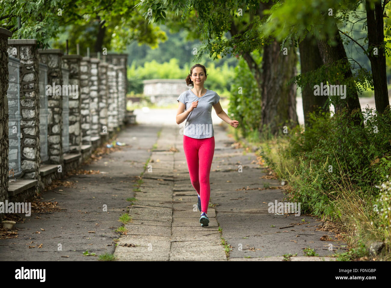 Joven Mujer jogging ejecutando durante el verano Park Road. Modelo de  Fitness Sport etnia caucásica capacitación al aire libre Fotografía de  stock - Alamy
